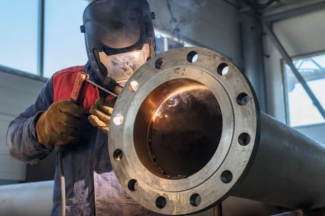 A welder working on a pipe