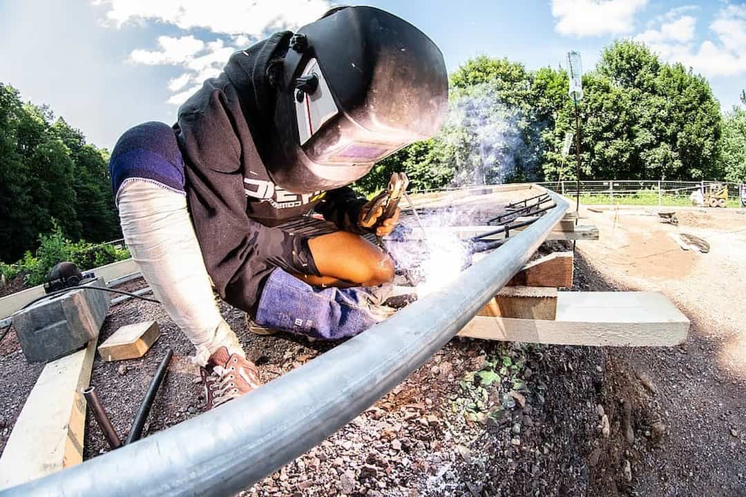 A person welding the metal pipe
