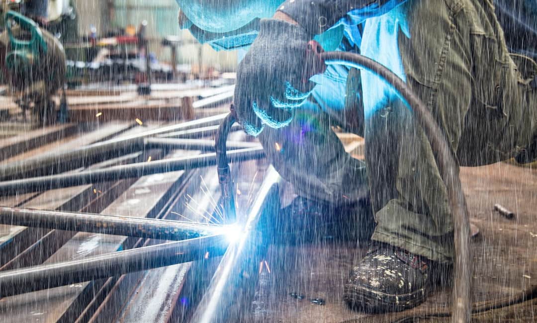 A person welding on a rainy day