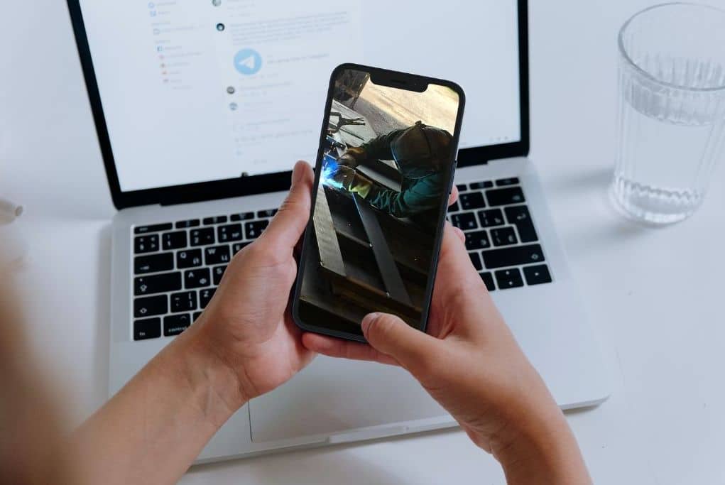 A person holding a phone with a welder's photo on the screen